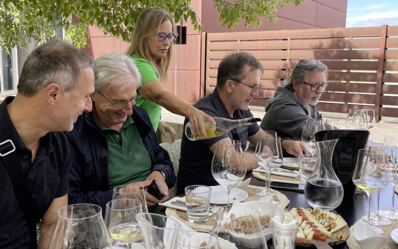 Person schenkt am Tisch Wein in ein glas ein
