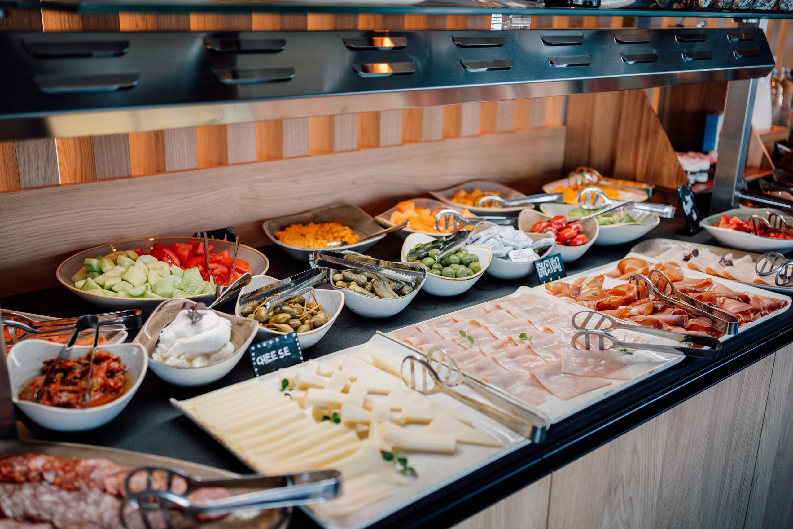 Frühstücksbuffet mit einer Auswahl an frischem Gemüse, Käse, Wurst und eingelegten Spezialitäten.