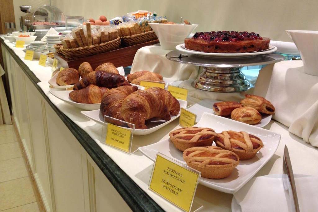 Frühstücksbuffet im Ambassador Palace Hotel mit Croissants, Kuchen und Gebäckauswahl.