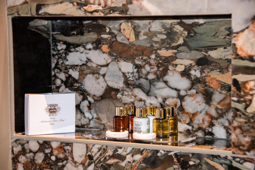 Detailaufnahme von Pflegeprodukten im Badezimmer des Ambassador Palace Hotels auf Natursteinablage.