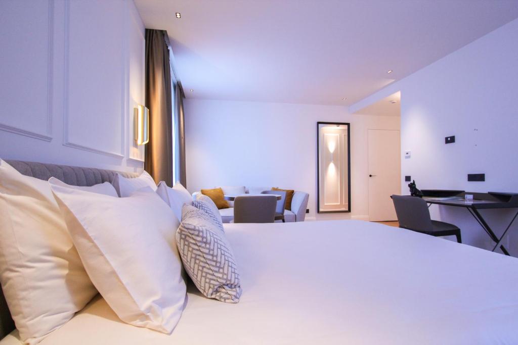 Großzügiges Hotelzimmer im Ambassador Palace Hotel mit Doppelbett, Sofa und Arbeitsbereich.