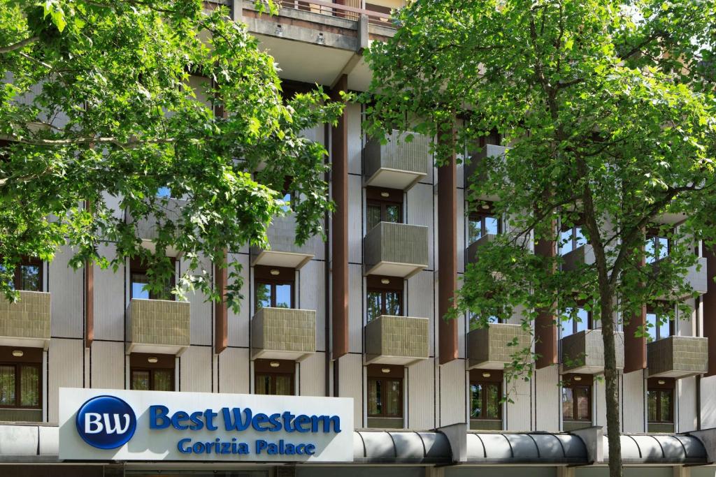 Moderne Außenansicht des Best Western Gorizia Palace Hotels mit Balkonen und grünen Bäumen im Stadtzentrum von Gorizia.