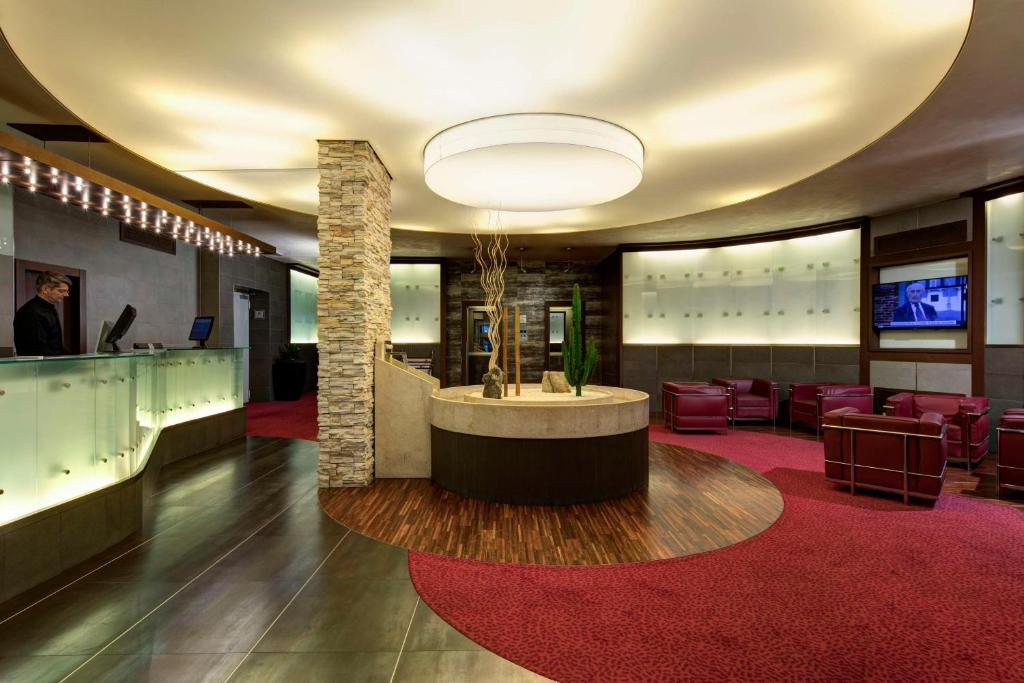 Elegante Hotellobby im Best Western Gorizia Palace mit Rezeption, Sitzlounge und modernem Lichtkonzept.