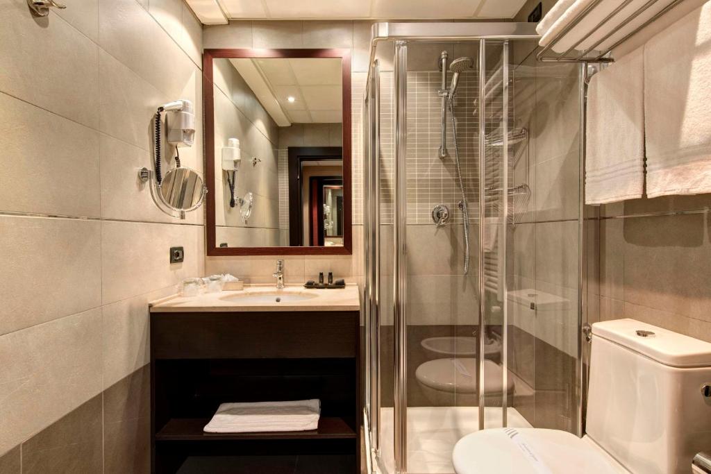 Modernes Hotelbad mit Dusche, Waschbecken und hochwertigen Pflegeprodukten im Best Western Gorizia Palace.