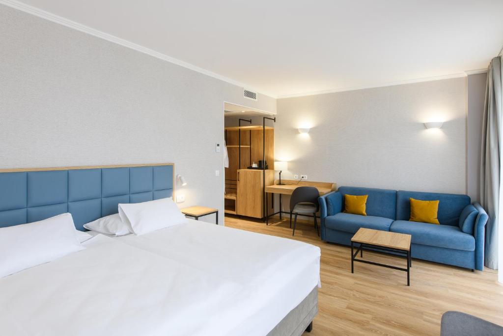 Komfortables Hotelzimmer im Eurostars uHOTEL Ljubljana mit Doppelbett, Schreibtisch und Sitzmöbeln.