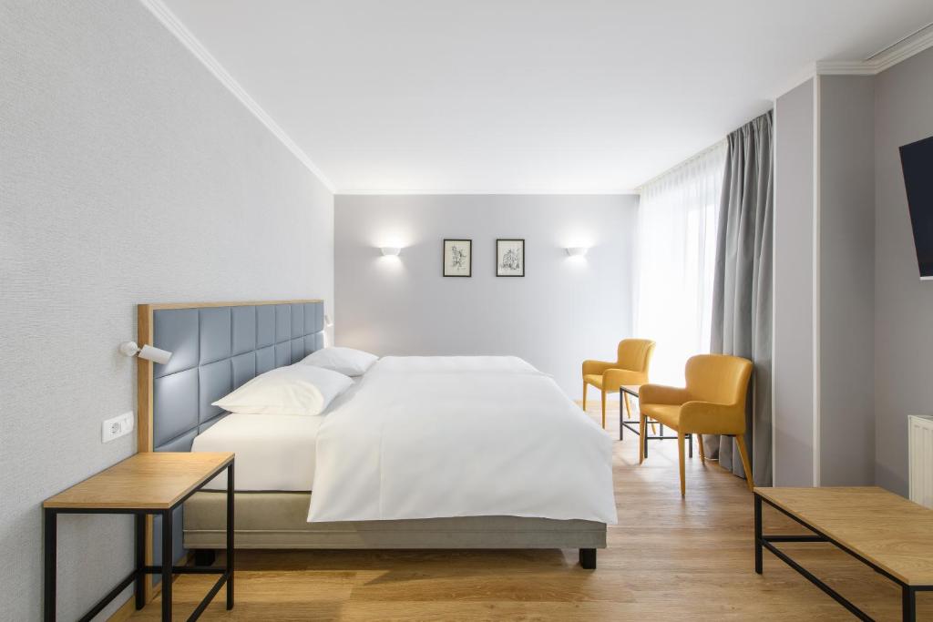 Hotelzimmer im Eurostars uHOTEL Ljubljana mit zusätzlichem Schlafsofa und Blick auf die Stadt.