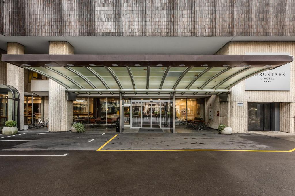 Außenansicht und Hoteleingang des Eurostars uHotel mit überdachtem Vorfahrtbereich und automatischen Türen.
