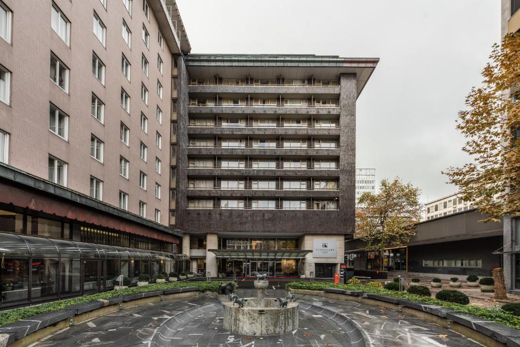 Außenansicht des Eurostars uHOTEL mit Vorplatz, Brunnen und Hotelzufahrt.