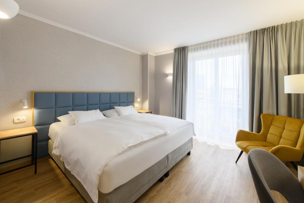 Komfortables Doppelzimmer im Eurostars uHotel mit gepolstertem Kopfteil, großem Bett und ruhiger, heller Raumgestaltung.