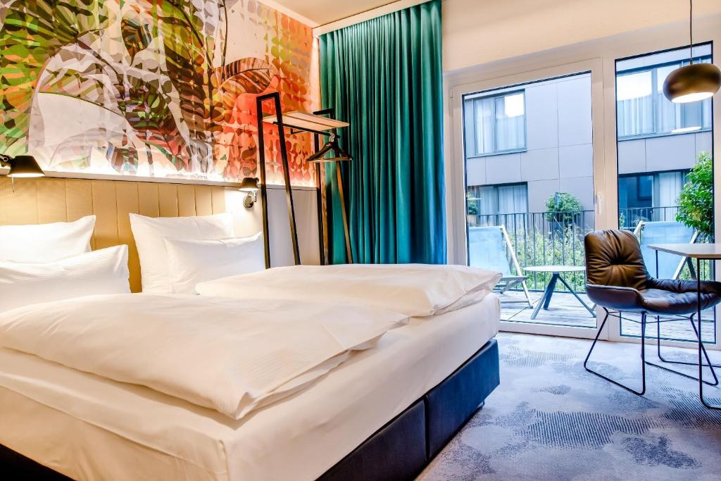 Modernes Doppelzimmer mit Balkon, Designmöbeln und viel Tageslicht im Motel One Wien Donau City.