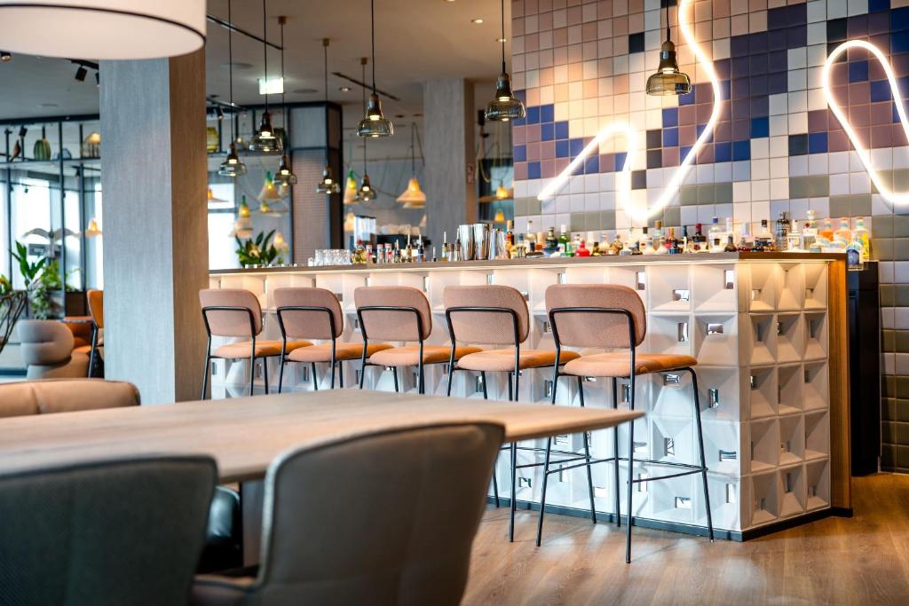 Design-Bar mit Barhockern, moderner Beleuchtung und urbanem Ambiente im Motel One Wien Donau City.