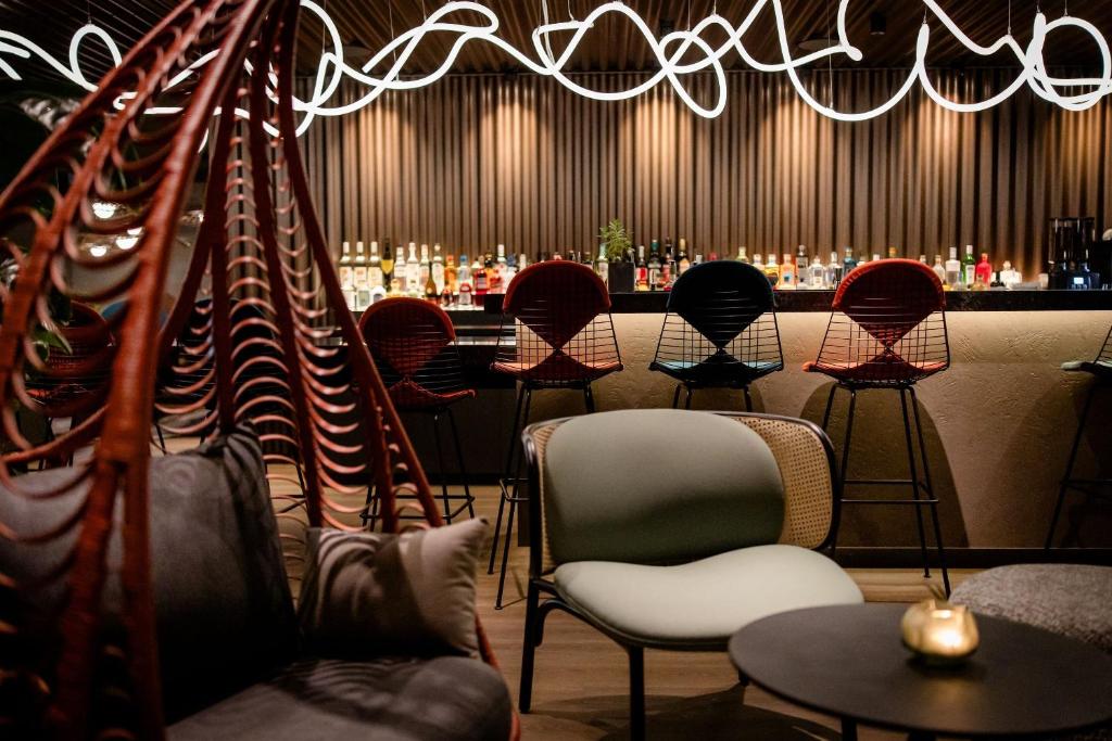 Design-Bar im Motel One Wien Donau City mit stilvollen Barhockern, beleuchteter Theke und moderner Lounge-Atmosphäre.