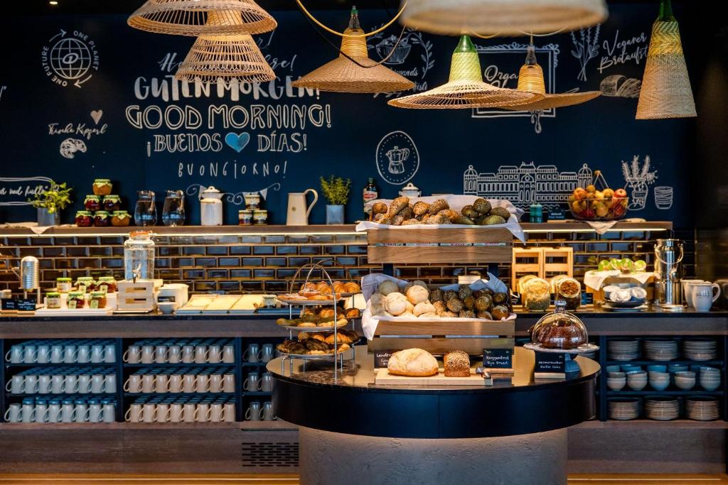 Frühstücksbereich im Motel One Wien Donau City mit großzügigem Buffet, frischen Backwaren und modernem Design.