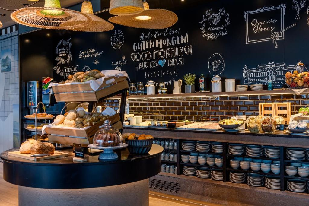 Frühstücksbuffet im Motel One Wien Donau City mit Brotauswahl, Gebäck, Müsli und liebevoll präsentierten Speisen.