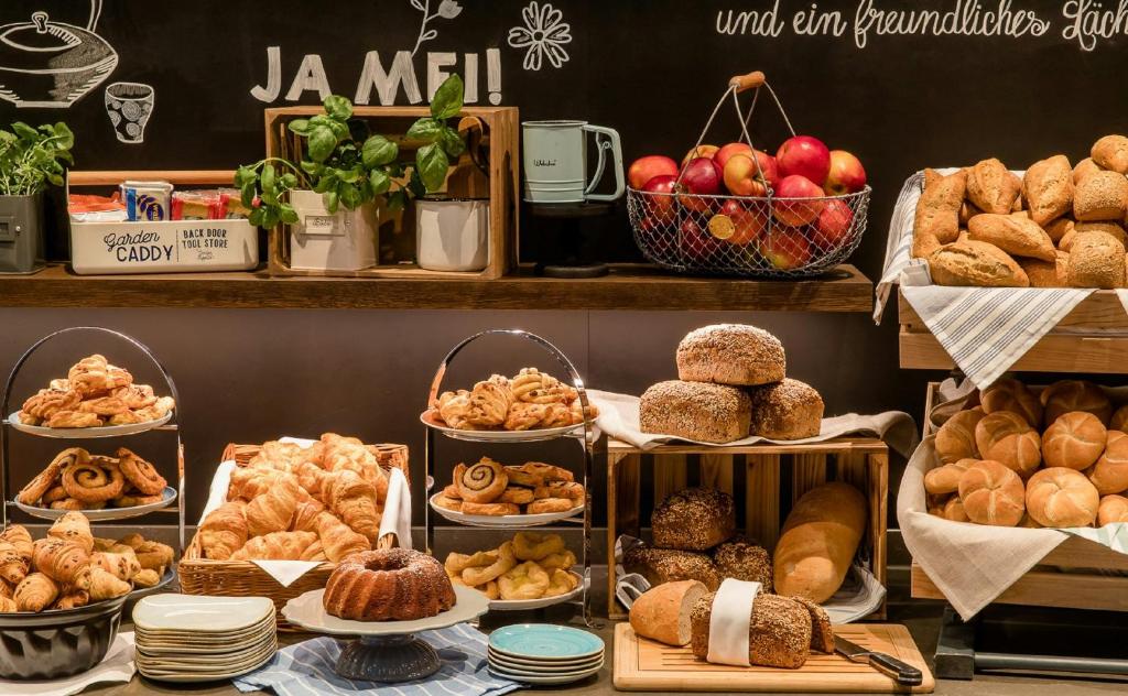 Detailaufnahme des Frühstücksbuffets im Motel One Wien Donau City mit frischem Gebäck, Brotvariationen und liebevoll arrangierten Speisen.