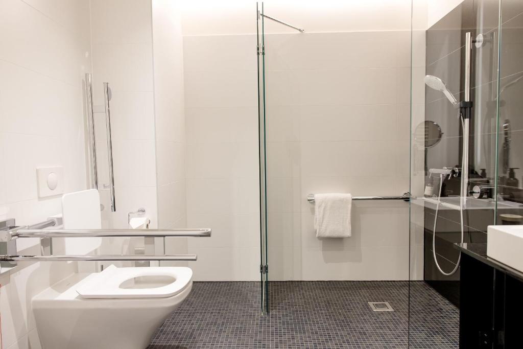 Barrierefreies Badezimmer im Motel One Wien Donau City mit bodengleicher Dusche, Haltegriffen und moderner Ausstattung.