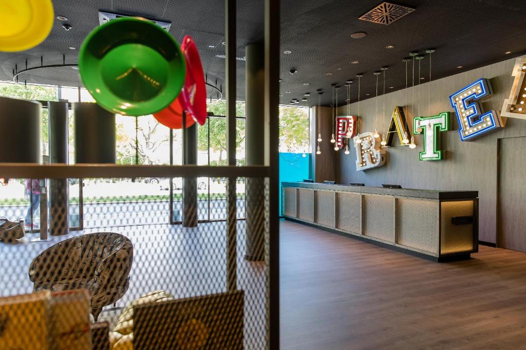 Rezeption des Motel One Wien Prater mit auffälligem Schriftzug und moderner Inneneinrichtung.