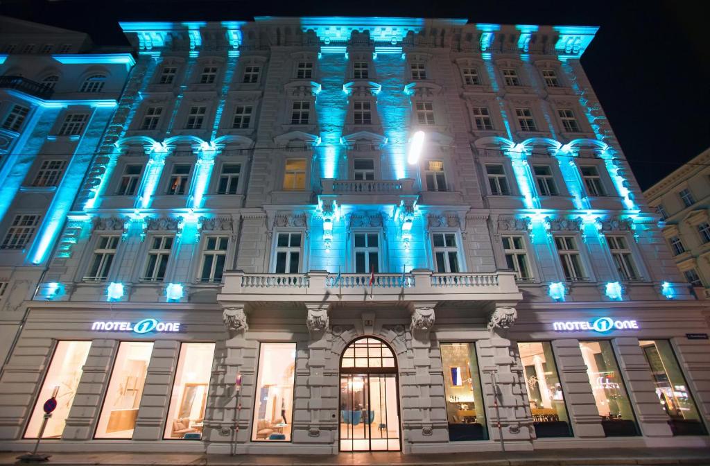 Außenansicht des Motel One Wien Staatsoper bei Nacht mit beleuchteter historischer Fassade, Eingangsbereich und zentraler Lage in der Wiener Innenstadt.