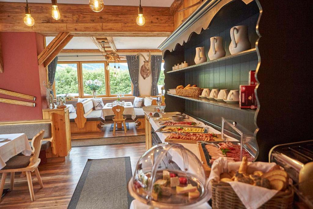 Frühstücksbuffet in der Pension Enzian mit regionalen Produkten, Brot, Käse und Wurst in alpinem Ambiente.