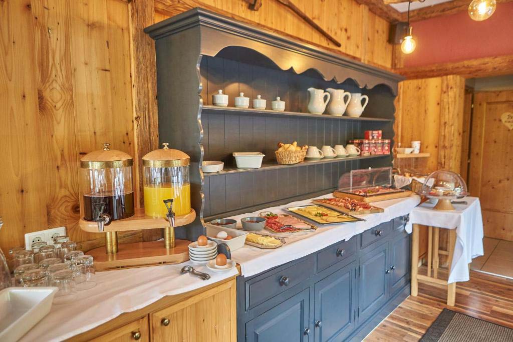 Detailaufnahme vom Frühstücksbuffet der Pension Enzian mit Aufschnitt, Käse und regionalen Spezialitäten.