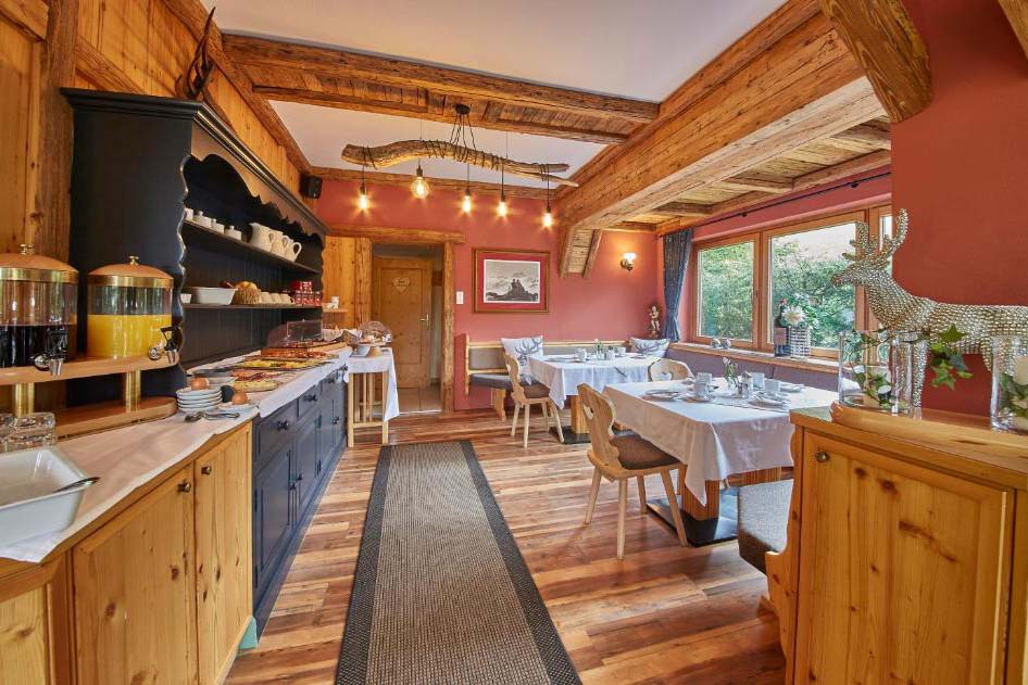 Detailansicht des Frühstücksraums der Pension Enzian mit Buffetbereich und traditioneller Holzeinrichtung.