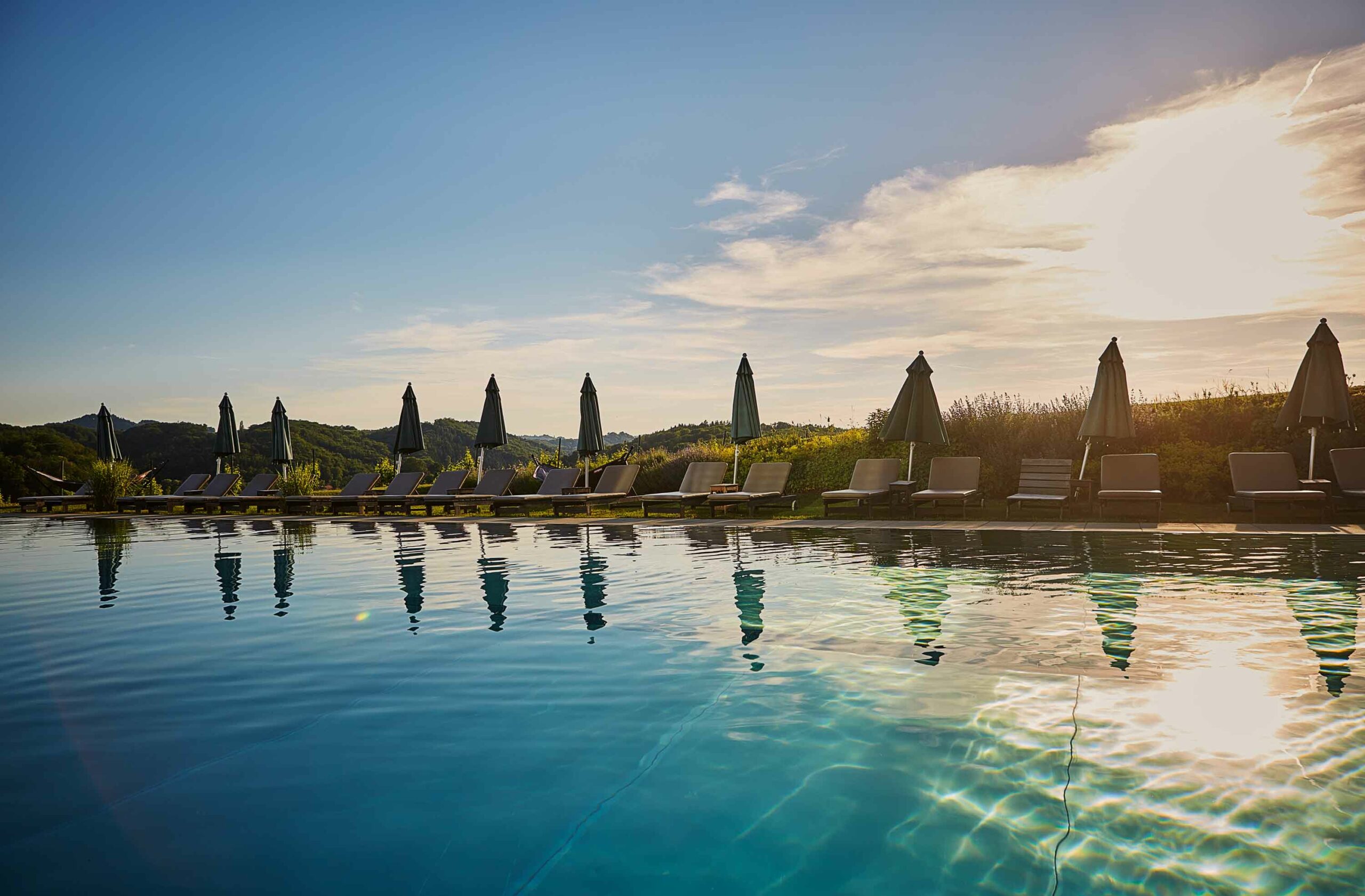 Infinity-Pool im LOISIUM Wine & Spa Hotel Südsteiermark bei Sonnenuntergang mit Blick über die Hügel der Südsteiermark.