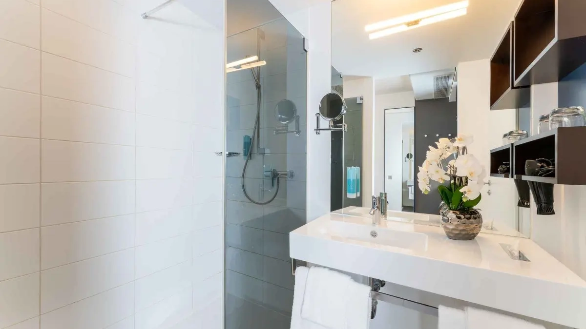 Modernes Badezimmer im Hotel Plaza Inn Graz mit großzügiger Dusche – komfortabler Aufenthalt während der Casinos Golf EM.